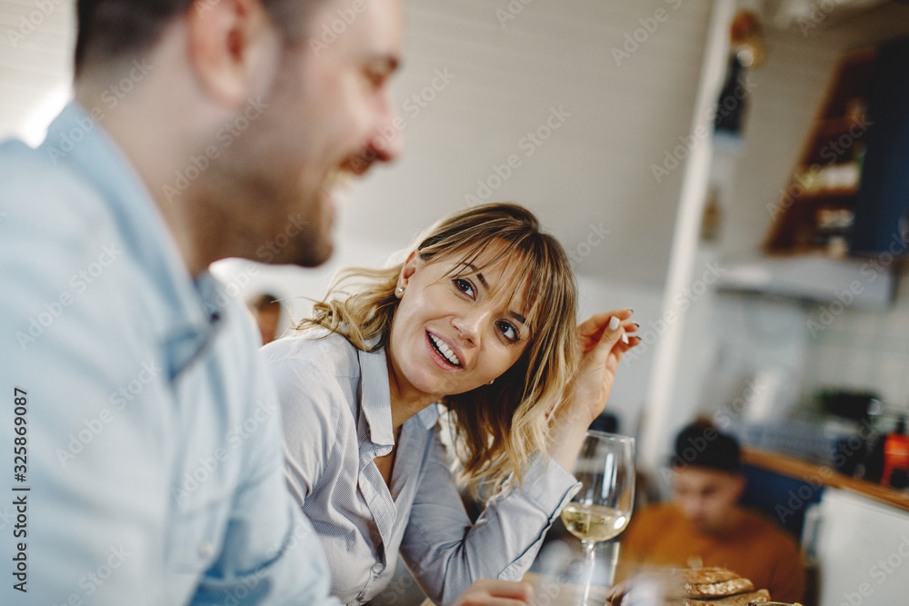 Happy woman communicating with her husband during a meal at dining table. Happy woman communicating with her husband during a meal at dining table.