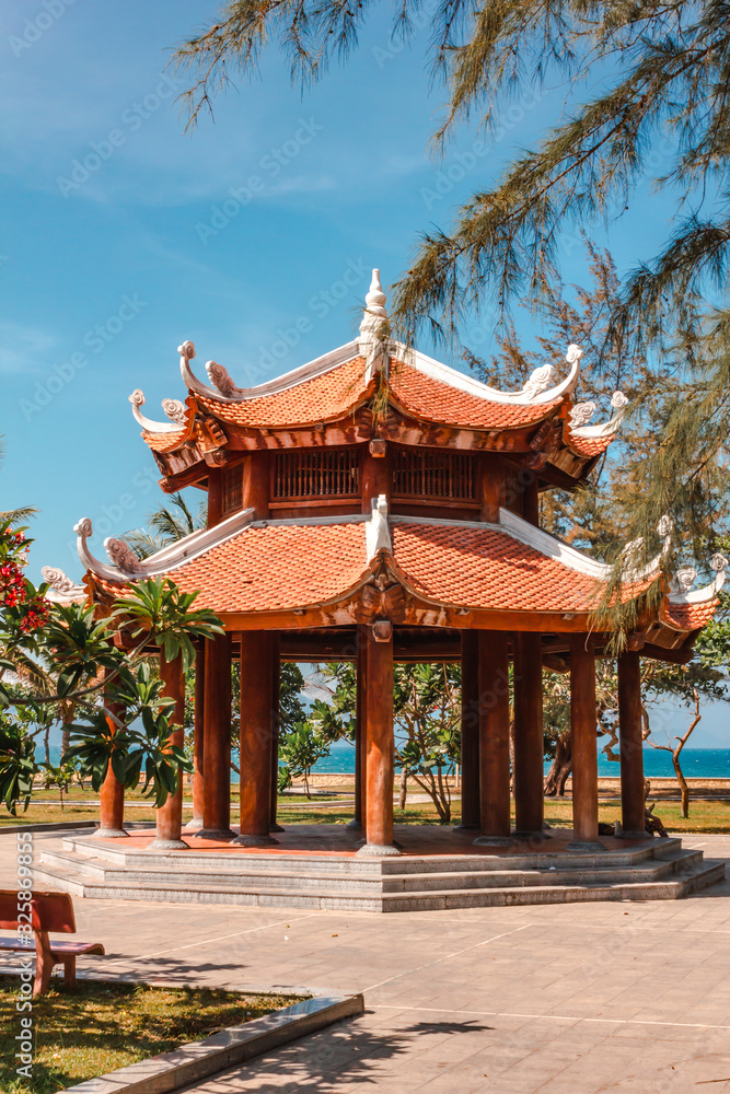 Oriental-style gazebo surrounded by trees and the sea