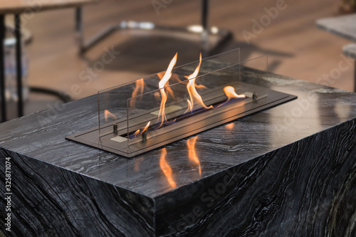 Beautiful marble black floor fireplace. Minimalism interior, alternative bio fireplot fireplace on ethanol gas