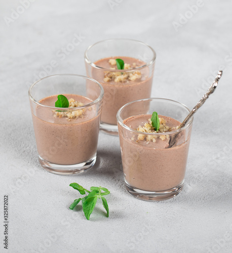 Chocolate nut jelly in a glass on a light background