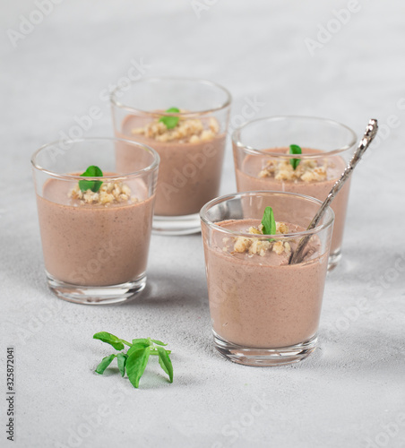 Chocolate nut jelly in a glass on a light background