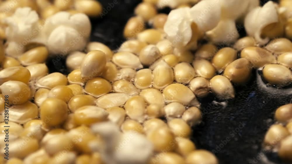 Corns seeds popping in a frying pan with some oil slow motion footage. Corns seeds popping in a frying pan with some oil slow motion footage.