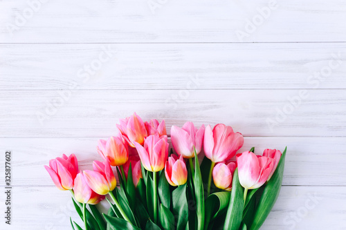 Fresh pink tulip flowers on wooden table. Top view with copy space