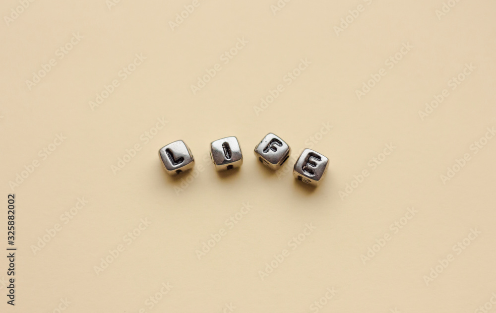 The word life is laid out in cubes with letters. Empty space for text. The word life is laid out in cubes with letters. Empty space for text.