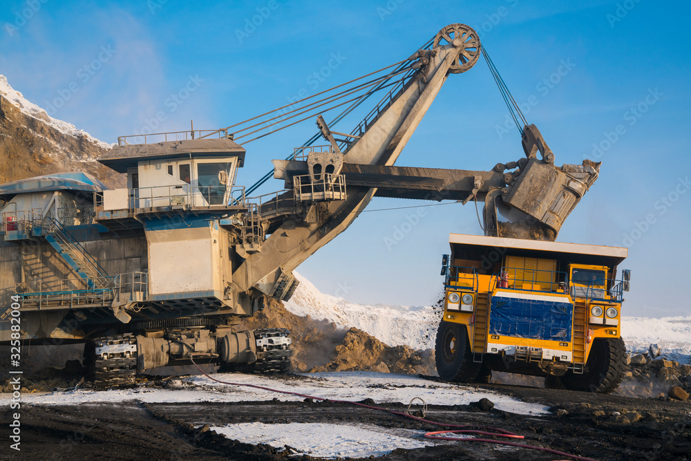 Loading coal into a truck with an excavator. Mine Loading coal into a truck with an excavator. Mine