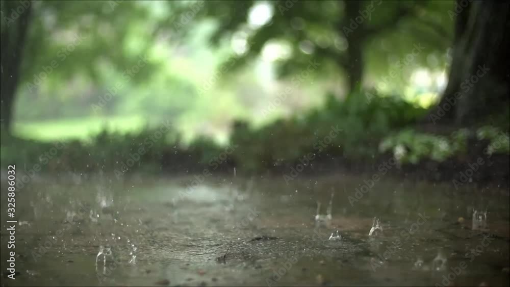 Picturesque close up satisfying steady slow motion shot of downpour rain drops falling on pavement asphalt concrete road Picturesque close up satisfying steady slow motion shot of downpour rain drops falling on pavement asphalt concrete road