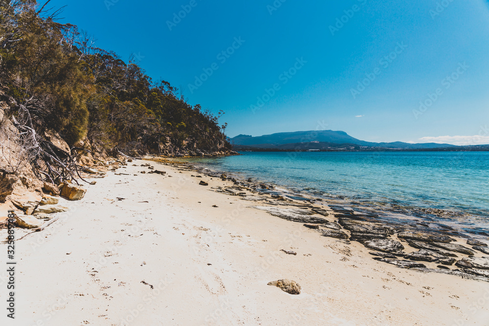 wild Tasmanian landscape and pristine turquoise water of the Derwent River as seen from Legacy Beach