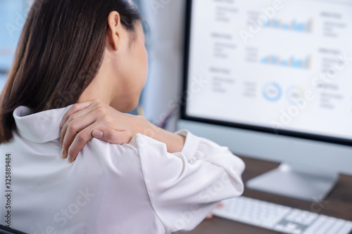 Business women have shoulder pain to working on a computer screen for a long time. May be office syndrome.