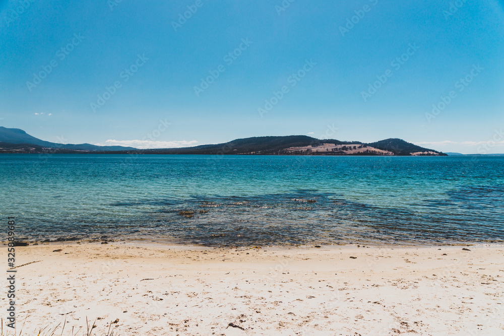 wild Tasmanian landscape and pristine turquoise water of the Derwent River as seen from Legacy Beach near Coningham beach south of Hobart