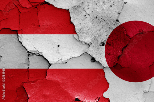 flags of Austria and Japan painted on cracked wall
