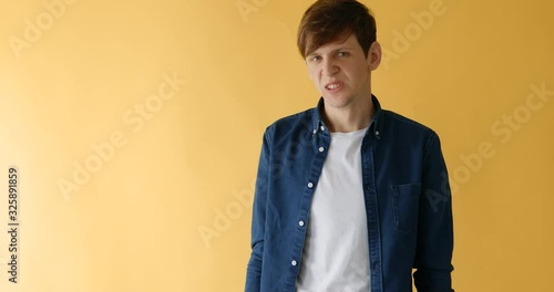 the man does not agree, the gesture is not, waving his head in disagreement on a yellow background