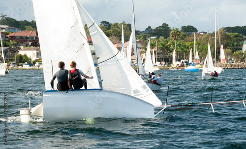 Children about to capsize a small racing sailboat. Commercial use image.