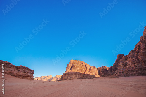 Textured sand mountains of red and orange sand against the blue sky  Jordan  Wadi Rum desert.