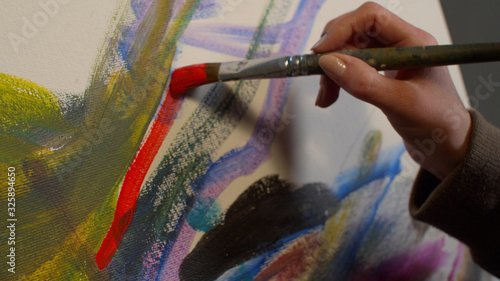 Woman draws a picture with paints, close up