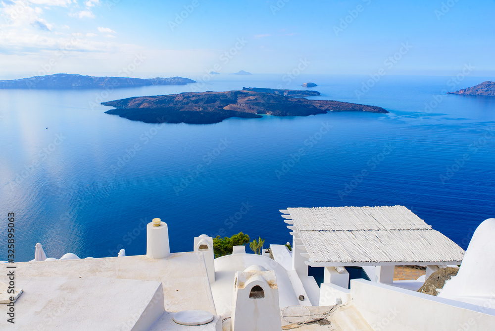 Obraz premium White buildings and hotels with panoramic view of Aegean Sea in Fira, Santorini, Greece