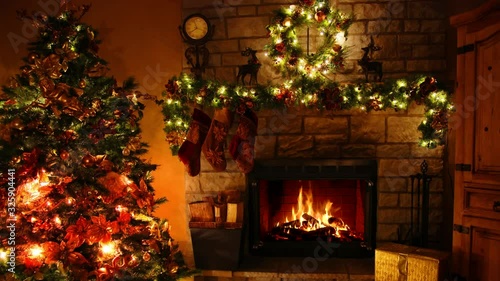 Wonderful 4k shot of firewood flame burning fireplace loop in cosy festive Christmas tree New Year decoration Noel room