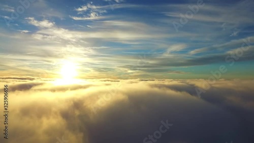 Stunning aerial helicopter drone view flight over white rain fluffy cloud in blue sky evening sunset sunshine cloudscape