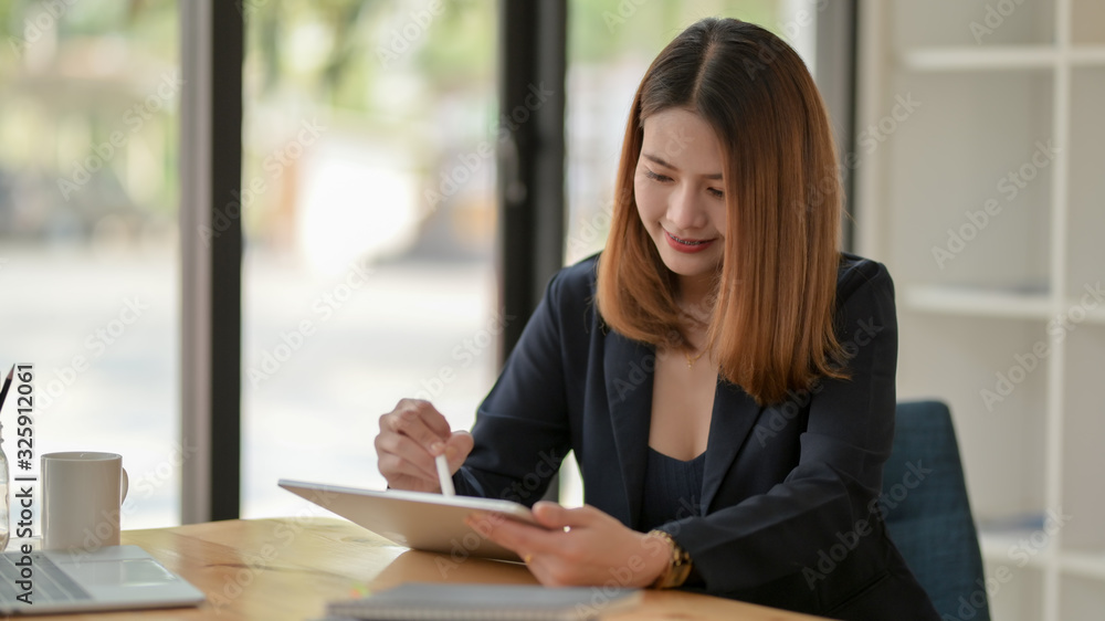 Cropped shot of businesswoman writing on digital tablet on wooden desk Cropped shot of businesswoman writing on digital tablet on wooden desk