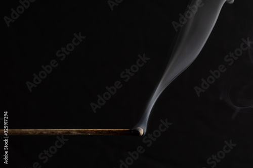 burned match still smoking against a black background