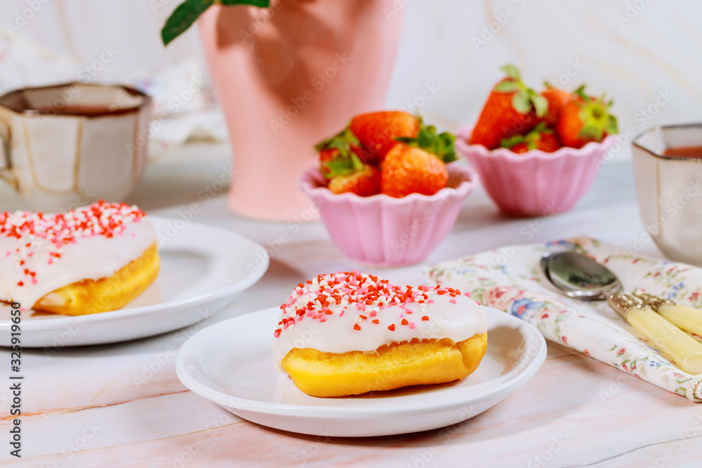 Breakfast with sweet sprinkle donut, strawberry and cup of coffee. Breakfast with sweet sprinkle donut, strawberry and cup of coffee.