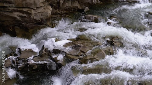 Wild Mountain River Flowing with Stone Boulders and Stone Rapids. Slow Motion photo