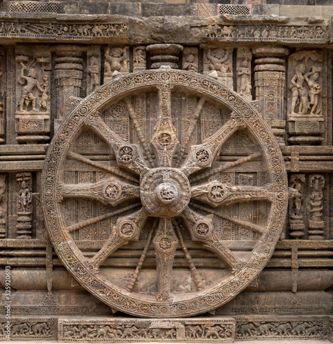 A stone wheel depicting time of a day photo