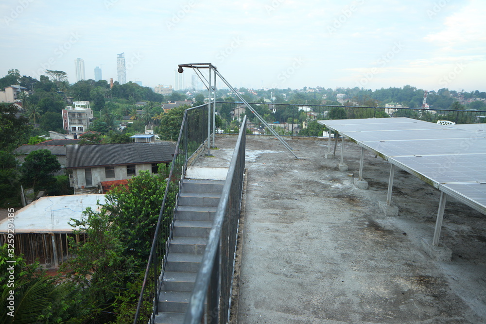 Solar panels on the roof of a tropical city house early in the morning at dawn.