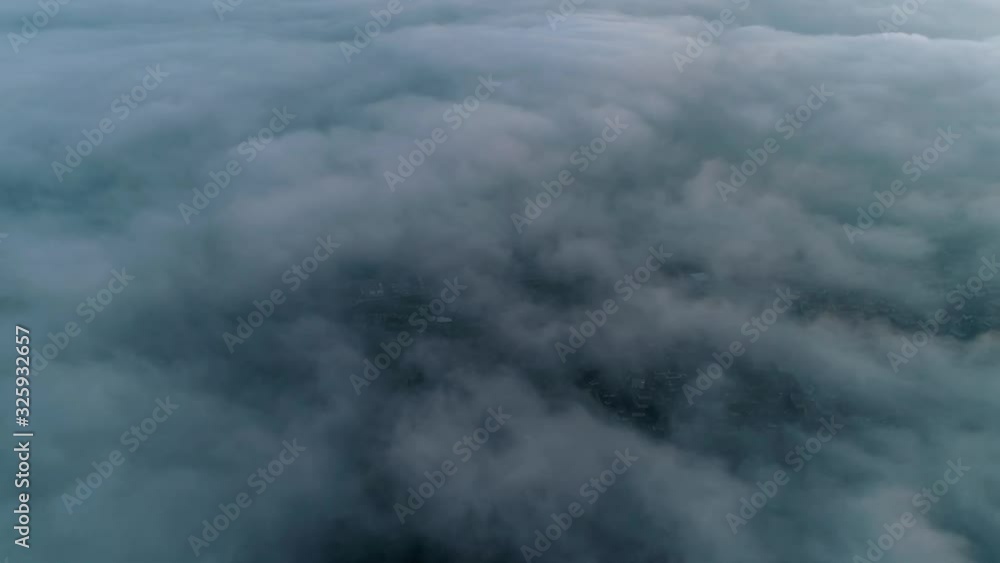 Picturesque 4k aerial drone shot of camera flying through dense fog heavy rain cloud in grey sky over mountain forest Picturesque 4k aerial drone shot of camera flying through dense fog heavy rain cloud in grey sky over mountain forest