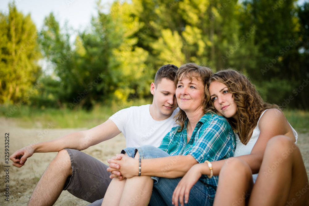 Naklejka premium Carefree children relaxing with their mother, outdoors.