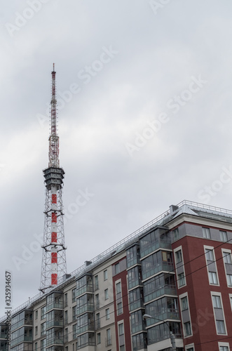 A residential house built on modern technologies. Radio-TV-transmitting object behind the house.