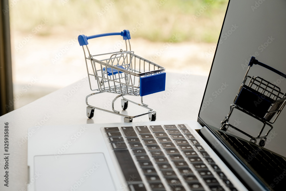 Cart placed next to a laptop keyboard Online shopping ideas