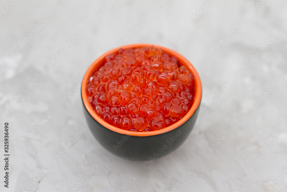 red caviar in a dish on a light table. the concept of a delicious Breakfast, buffet and snack. seafood dish. the view from the top. space for text. red caviar in a dish on a light table. the concept of a delicious Breakfast, buffet and snack. seafood dish. the view from the top. space for text.