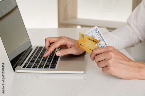 Business men use credit cards and laptops for online shopping and making payments the interne