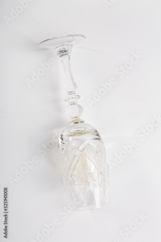 a glass of white wine lies on its side on a white background