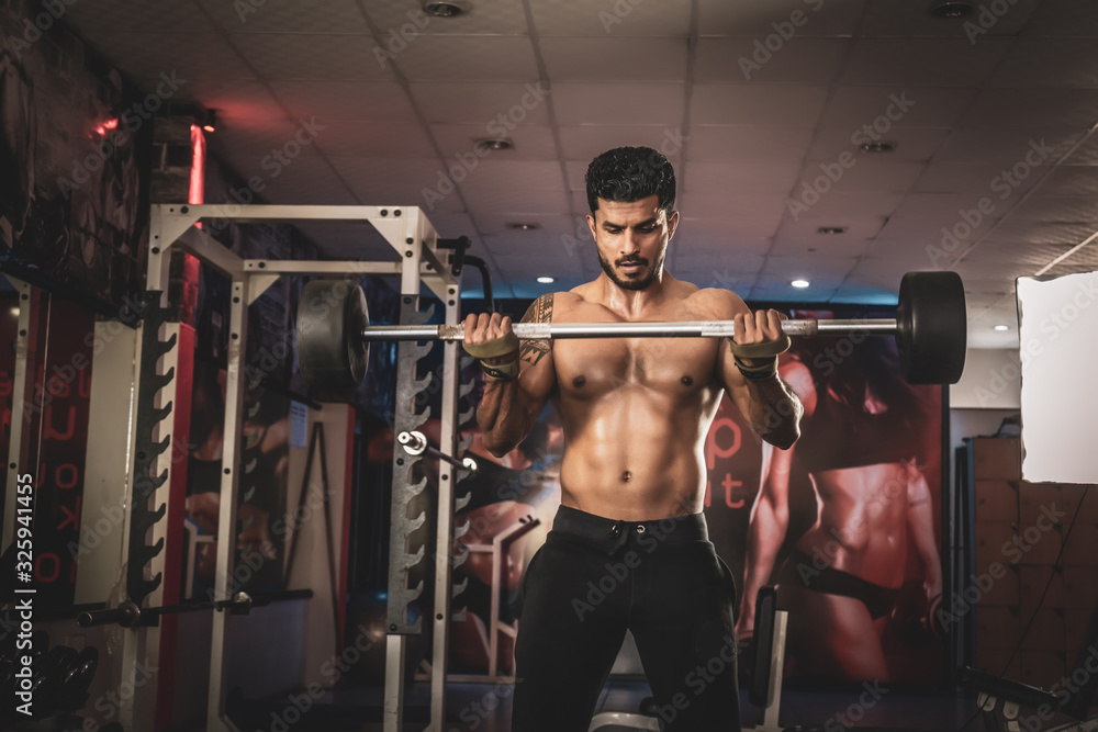 Men In The Gym Exercising Biceps With Barbell Men In The Gym Exercising Biceps With Barbell