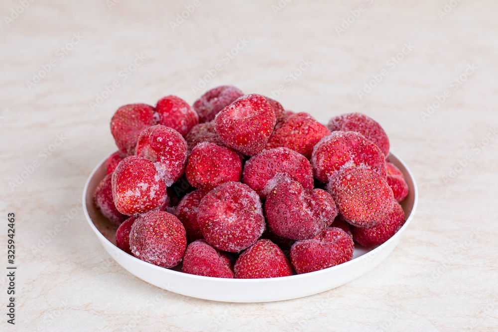 Frozen strawberries in a white plate Frozen strawberries in a white plate
