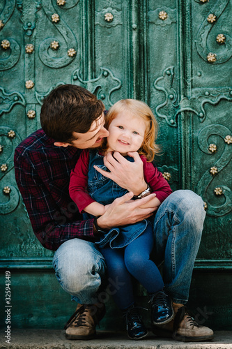 Happy family: dad hug and kiss daughter enjoying time together near old vintage building on the street city in country Europe. Close-up.