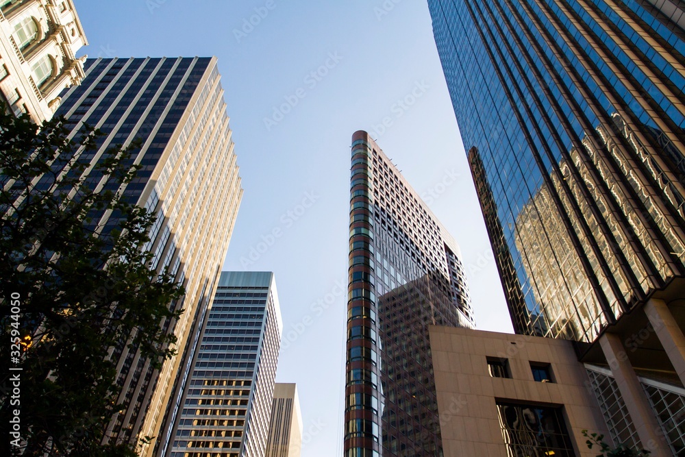 Modern skyscrapers in a financial district at sunset, looking up perspective, real estate and success concept, USA