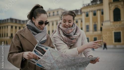 Two young girls tourists look at the map, have fun, laugh and argue. Vienna, Austria (Europe).