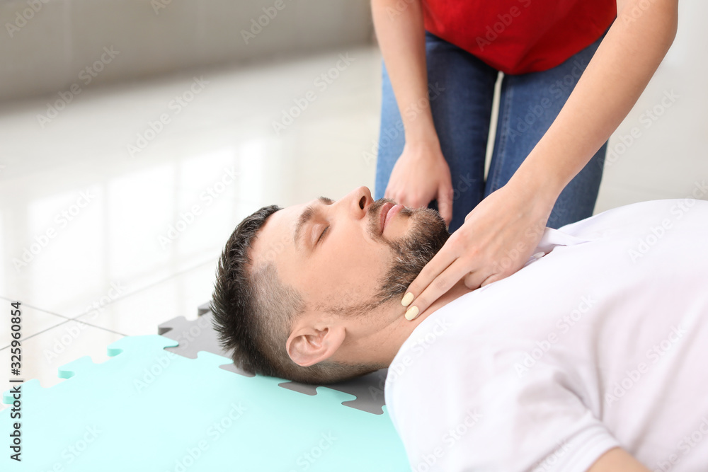 Fototapeta premium Instructor demonstrating CPR on man at first aid training course