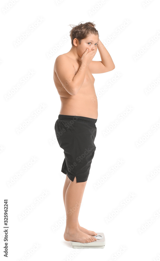 Overweight boy standing on scales against white background Overweight boy standing on scales against white background