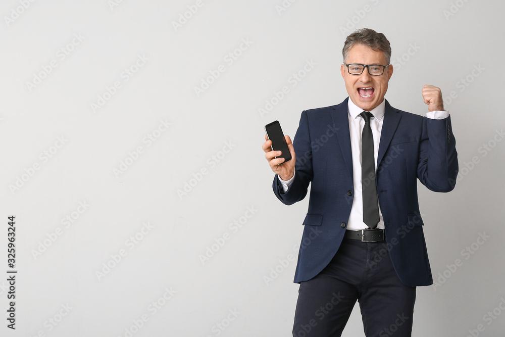 Happy businessman with mobile phone on white background