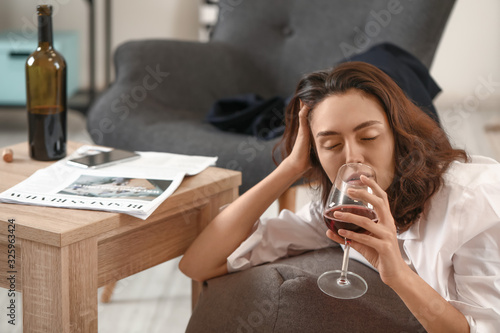 Woman drinking wine at home...