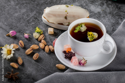 A cup of tea with nuts and flower blossoms