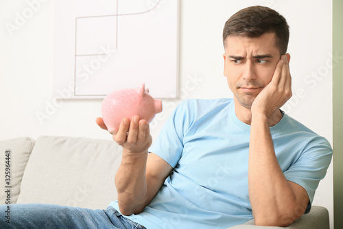 Displeased man with piggy b...