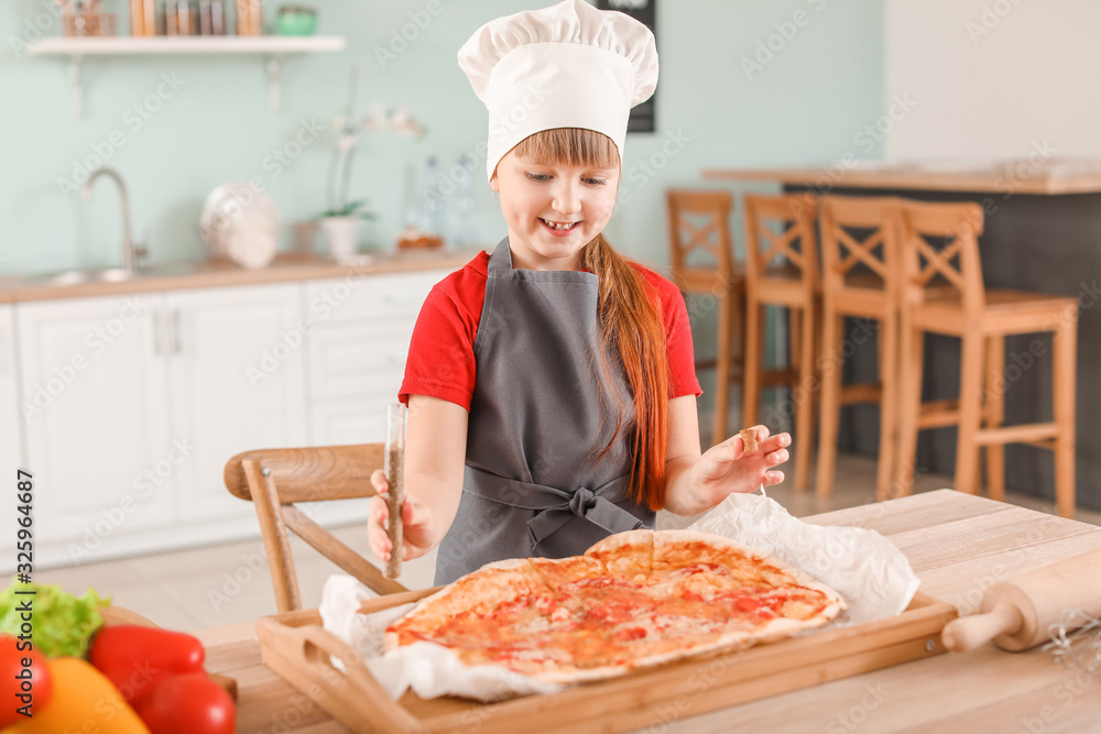 Cute little chef cooking pizza in kitchen Cute little chef cooking pizza in kitchen