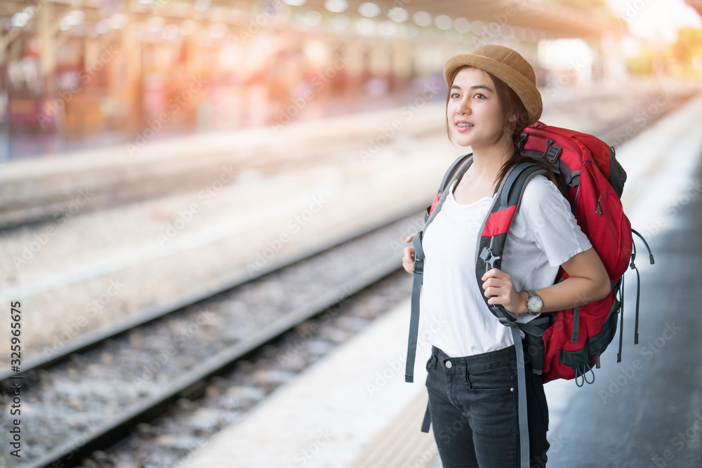 Obraz premium Portrait of young beautiful girl with backpack, standing looking map at the train station 