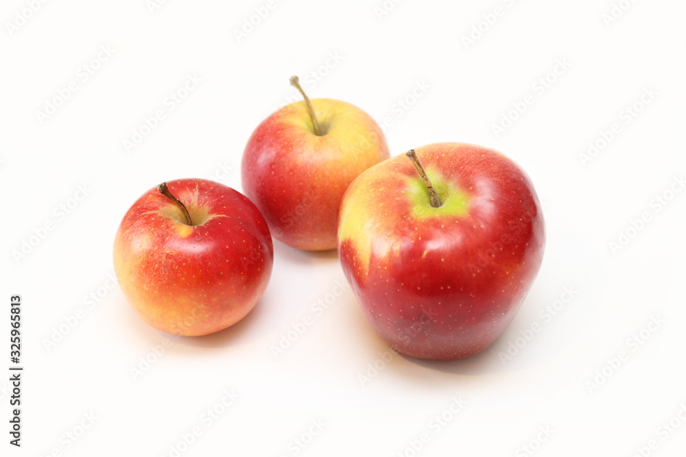 three red apples of different sizes on a white background three red apples of different sizes on a white background