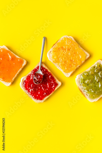 Toast with jam. Colorful set on yellow background top-down copy space
