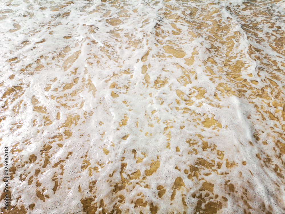 Golden sand and water on the seashore as a background